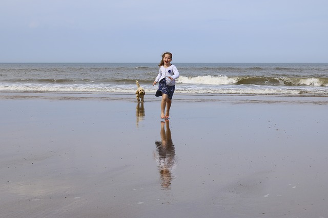 dívka se psem na pláži